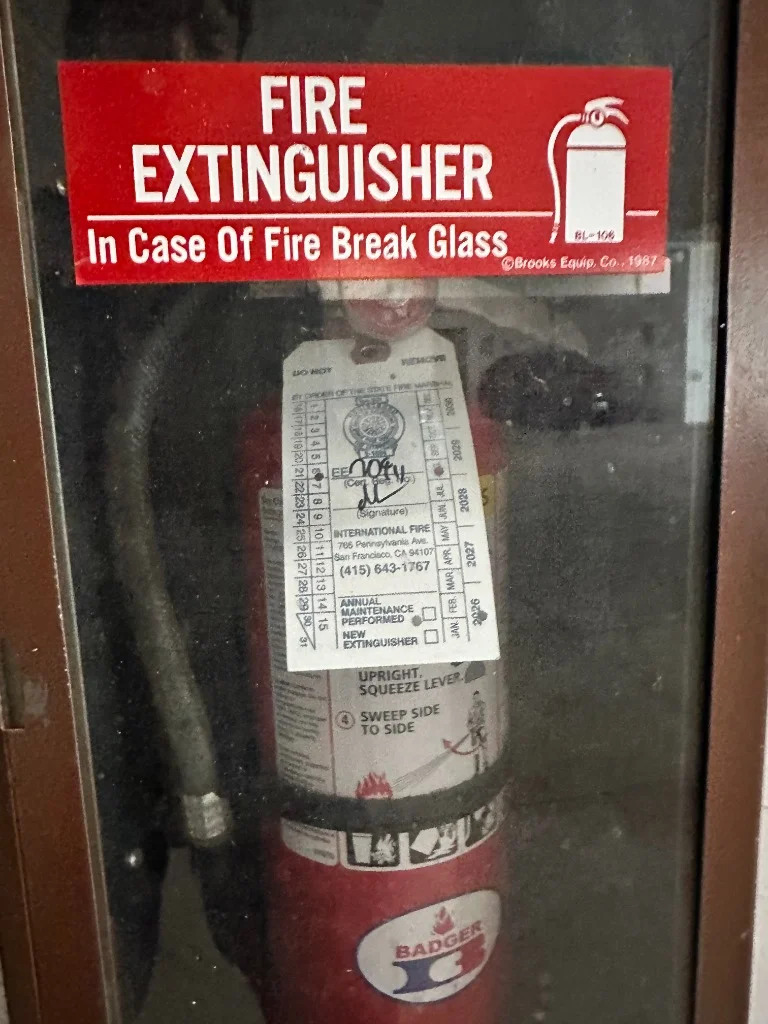Cabinet-housed Badger fire extinguisher with official California Title 19 certification tag at 501 Arguello Blvd by International Fire Inc.