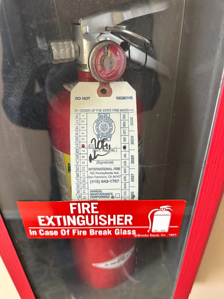 Wall-mounted glass front fire extinguisher cabinet at Ascendant restaurant in Richmond District, San Francisco.