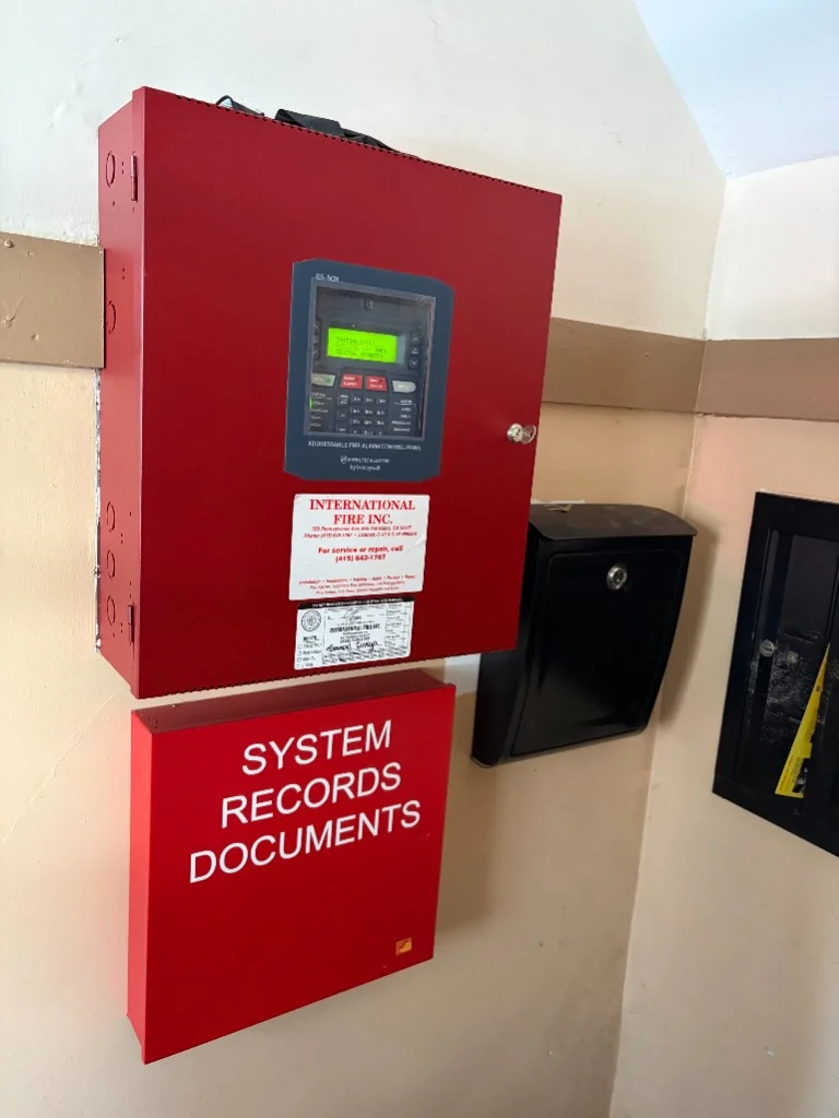 Fire-Lite ES-50X addressable fire alarm control panel and red system records document cabinet installed in Fillmore District, San Francisco by International Fire Inc.