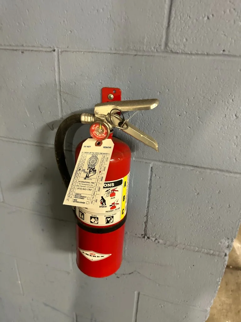 Inspected fire extinguisher on parking garage column at 4150 17th St multi-family residential building in Castro, San Francisco.